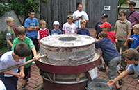 Kinder bedienen eine alte Mühle